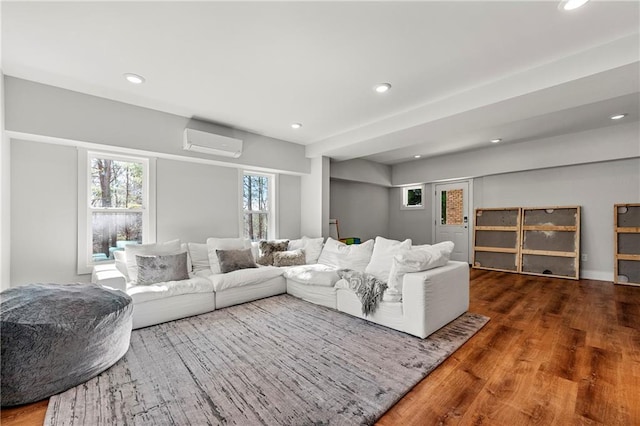 living room featuring wood-type flooring and a wall unit AC