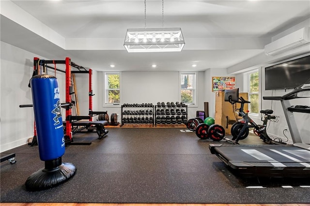 workout area with plenty of natural light and a wall unit AC