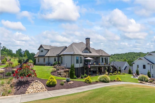 exterior space featuring central AC unit, stairs, fence, and a front yard