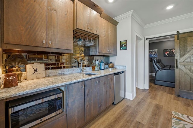 bathroom featuring crown molding, baseboards, wood finished floors, and vanity