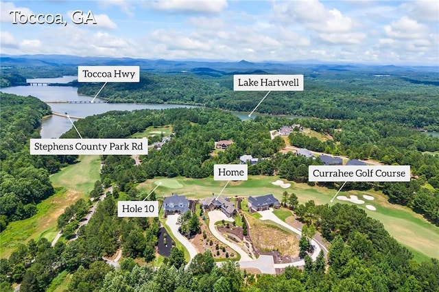 drone / aerial view featuring a view of trees, view of golf course, and a water view