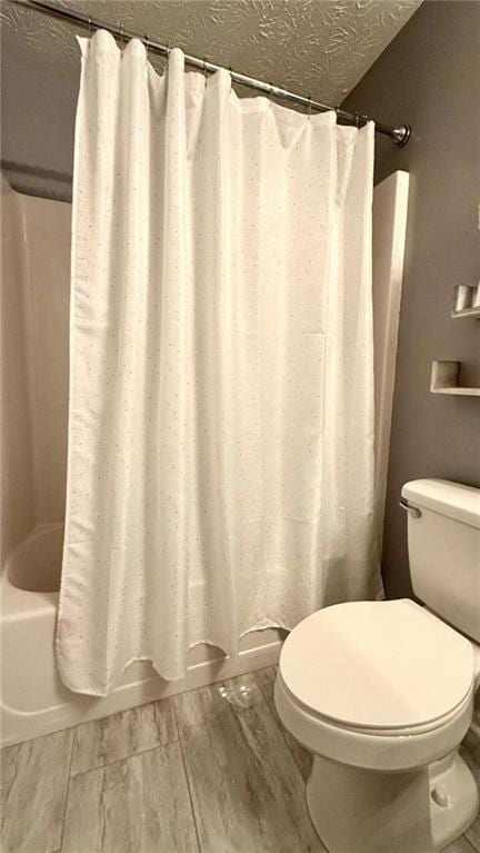 bathroom featuring shower / bathtub combination with curtain, a textured ceiling, wood tiled floor, and toilet