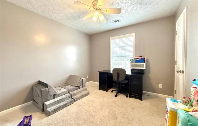 carpeted office with visible vents, baseboards, a ceiling fan, and a textured ceiling