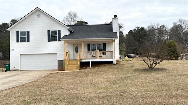 split level home with a chimney, driveway, a front lawn, a porch, and a garage