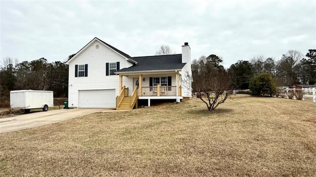 rear view of house with a yard, covered porch, a garage, a chimney, and driveway