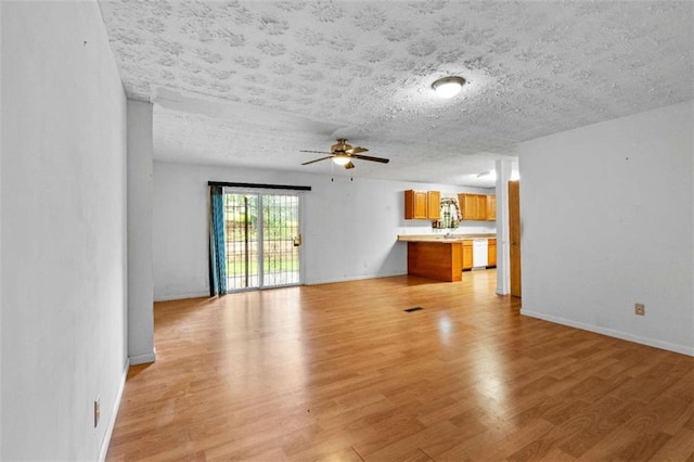 900 Fleetwood Cir, Atlanta, GA 30311 - unfurnished living room featuring light wood-type flooring, a ceiling fan, a textured ceiling, and baseboards
