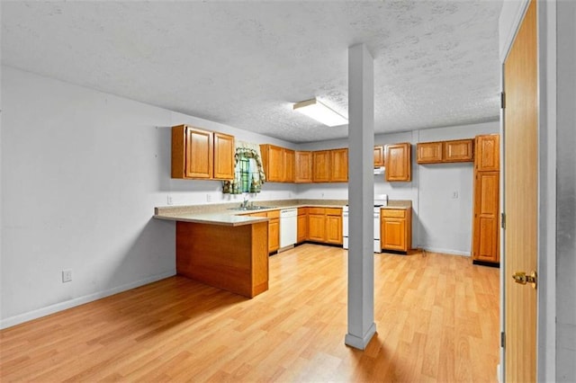 900 Fleetwood Cir, Atlanta, GA 30311 - kitchen featuring a peninsula, light wood-style flooring, brown cabinets, stove, and white dishwasher