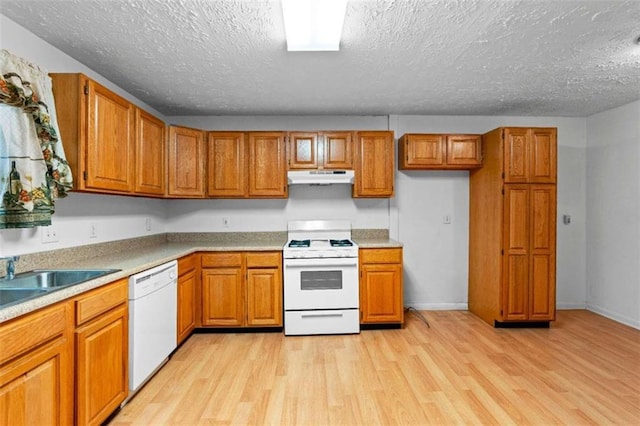 900 Fleetwood Cir, Atlanta, GA 30311 - kitchen featuring white appliances, under cabinet range hood, brown cabinets, light wood-style flooring, and a textured ceiling