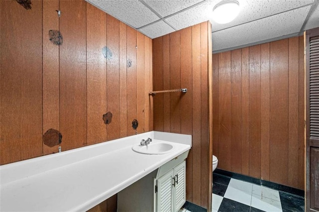 900 Fleetwood Cir, Atlanta, GA 30311 - bathroom featuring toilet, a sink, wooden walls, and a drop ceiling