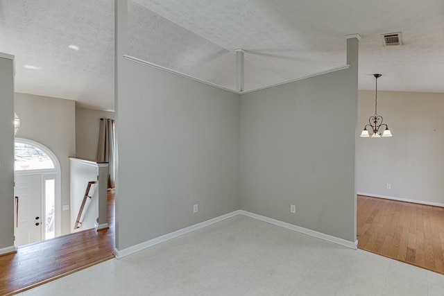 41 Pebble Ct, Hoschton, GA 30548 - spare room with visible vents, a notable chandelier, baseboards, and a textured ceiling
