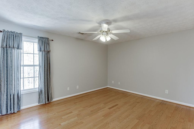 41 Pebble Ct, Hoschton, GA 30548 - spare room featuring a ceiling fan, a textured ceiling, light wood-style flooring, baseboards, and visible vents