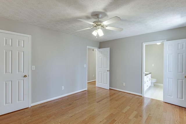 41 Pebble Ct, Hoschton, GA 30548 - unfurnished bedroom with baseboards, ensuite bath, a textured ceiling, and light wood-type flooring