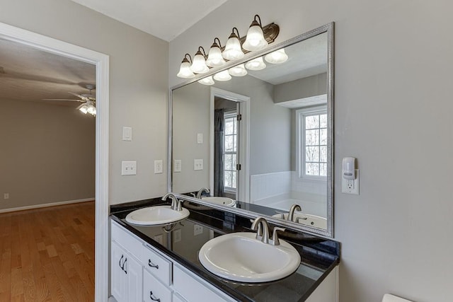 41 Pebble Ct, Hoschton, GA 30548 - full bath with double vanity, ceiling fan, a sink, and wood finished floors
