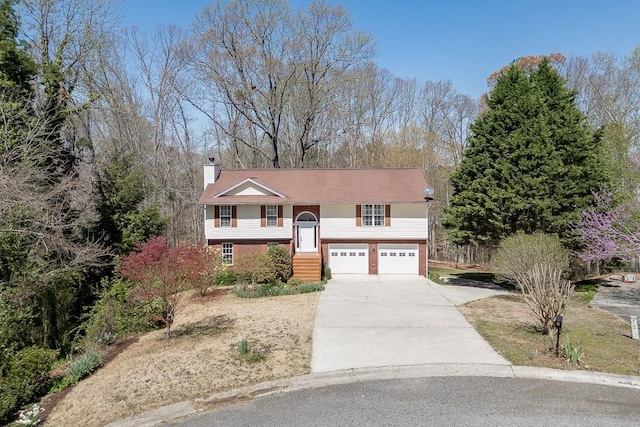 41 Pebble Ct, Hoschton, GA 30548 - split foyer home with an attached garage, a chimney, concrete driveway, and brick siding