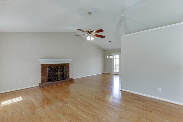 41 Pebble Ct, Hoschton, GA 30548 - unfurnished living room featuring lofted ceiling, ceiling fan with notable chandelier, baseboards, light wood-style floors, and a brick fireplace