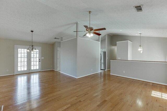 41 Pebble Ct, Hoschton, GA 30548 - unfurnished room with a textured ceiling, visible vents, light wood-type flooring, ceiling fan with notable chandelier, and vaulted ceiling