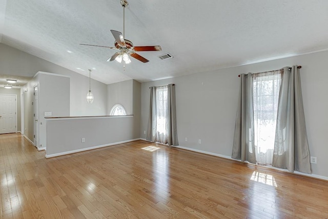 41 Pebble Ct, Hoschton, GA 30548 - unfurnished living room with a textured ceiling, light wood-style flooring, visible vents, ceiling fan, and vaulted ceiling
