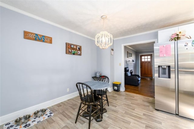 dining room featuring a notable chandelier, light wood-type flooring, and crown molding