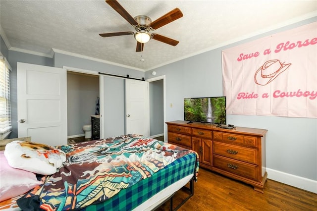 bedroom featuring ceiling fan, wood-type flooring, crown molding, a barn door, and a textured ceiling