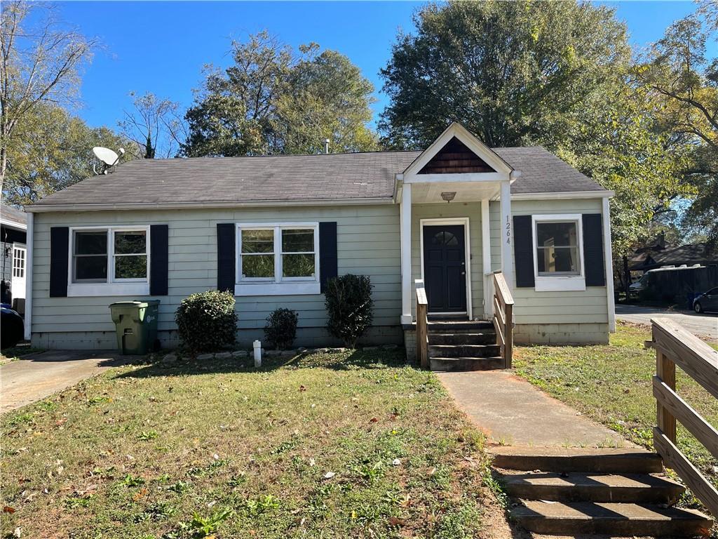 bungalow-style home with a front yard