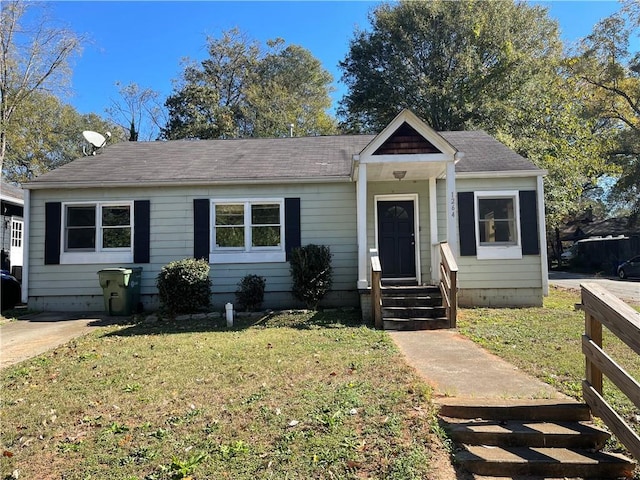 bungalow-style home with a front yard