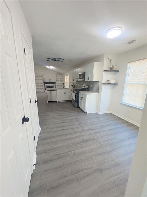 interior space with stainless steel fridge and wood-type flooring