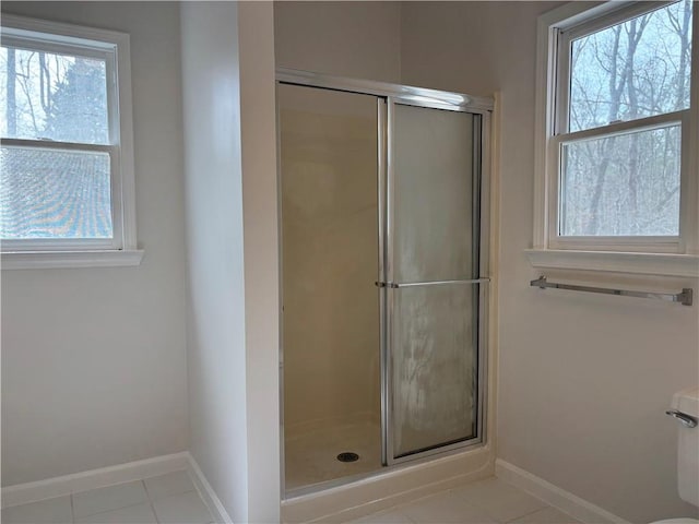 bathroom featuring a stall shower, tile patterned flooring, and baseboards