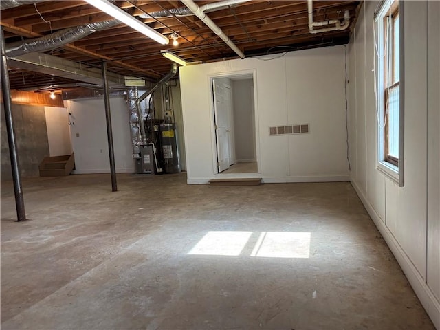 below grade area featuring stairway, gas water heater, and visible vents