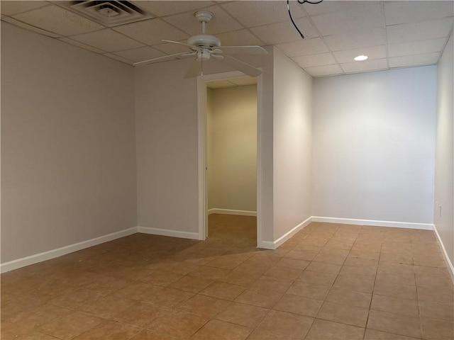 unfurnished room with a ceiling fan, a paneled ceiling, visible vents, and baseboards