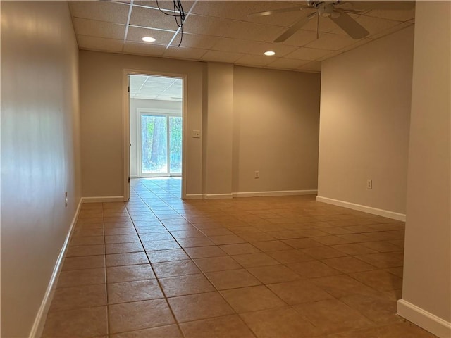 tiled spare room with recessed lighting, a drop ceiling, a ceiling fan, and baseboards