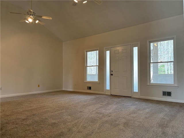 carpeted foyer entrance featuring vaulted ceiling, visible vents, plenty of natural light, and baseboards