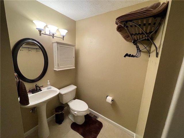 655 Chester Harris Dr, Dallas, GA 30132 - half bathroom featuring toilet, a textured ceiling, baseboards, and tile patterned floors