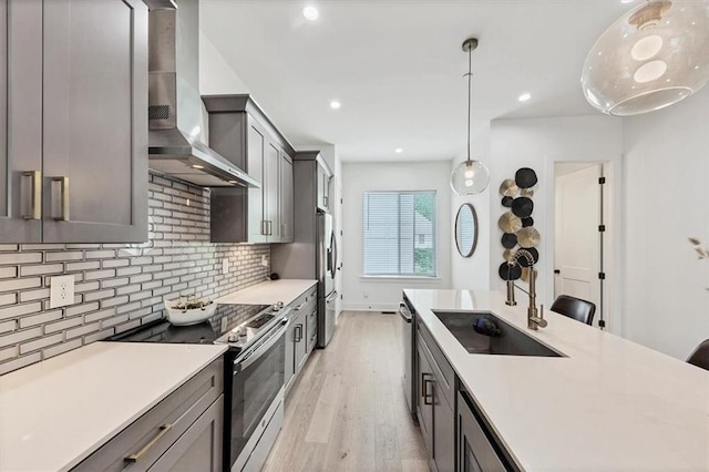 701 Pryor St SW Unit 5, Atlanta, GA 30315 - kitchen with appliances with stainless steel finishes, a sink, wall chimney range hood, light wood finished floors, and backsplash