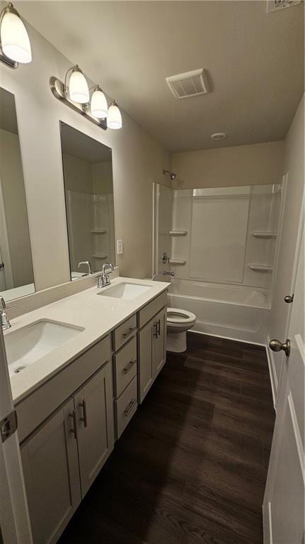 full bathroom with toilet, shower / bathing tub combination, wood-type flooring, and vanity