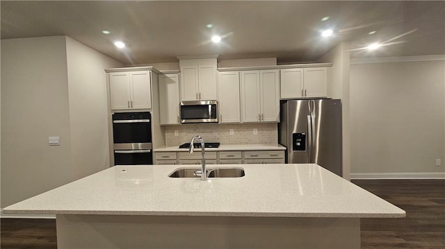 kitchen with a large island, backsplash, white cabinetry, appliances with stainless steel finishes, and sink