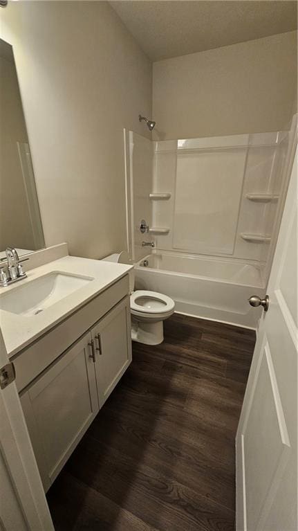 full bathroom with bathing tub / shower combination, toilet, vanity, and wood-type flooring