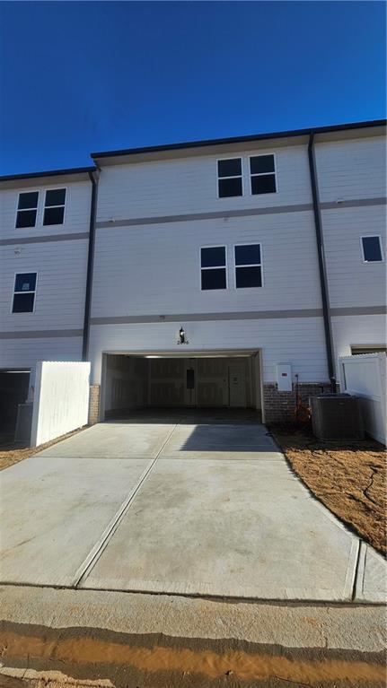 view of property featuring a garage and central AC unit