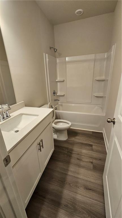 full bathroom featuring toilet, wood-type flooring, vanity, and washtub / shower combination