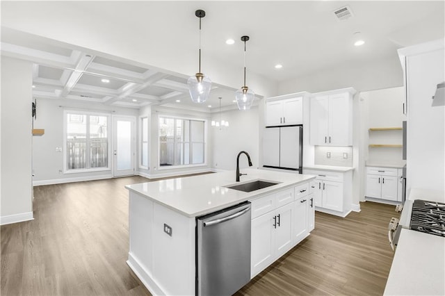 kitchen featuring light countertops, visible vents, stainless steel dishwasher, freestanding refrigerator, and a sink