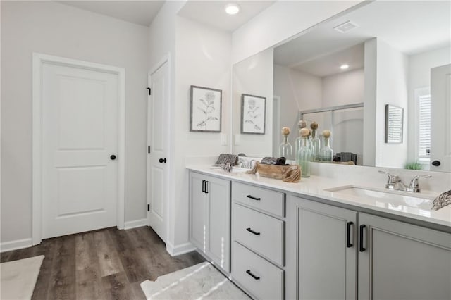 bathroom featuring vanity, a shower with shower door, and wood-type flooring