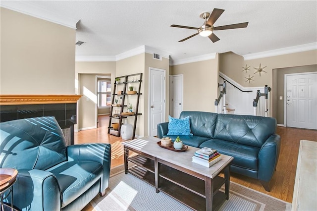 living room with ceiling fan, wood-type flooring, and ornamental molding