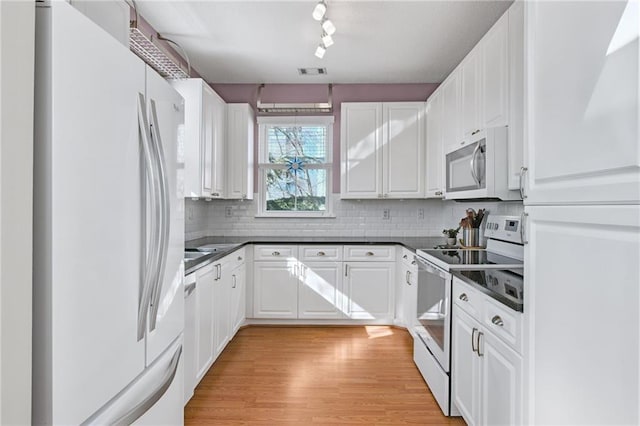 kitchen with white cabinets, white appliances, tasteful backsplash, and light hardwood / wood-style floors