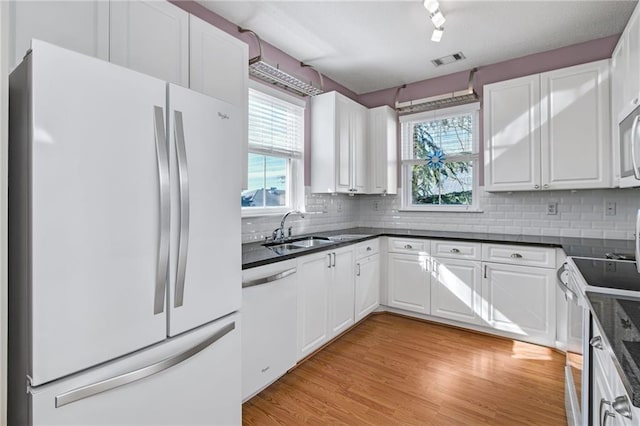 kitchen with white cabinets, a healthy amount of sunlight, and white appliances