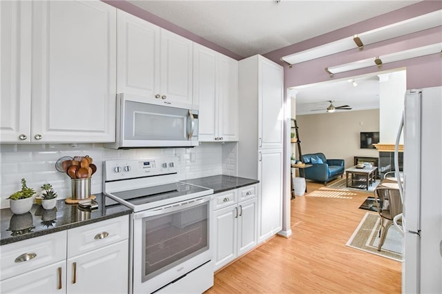 kitchen with decorative backsplash, white cabinetry, white appliances, and ceiling fan