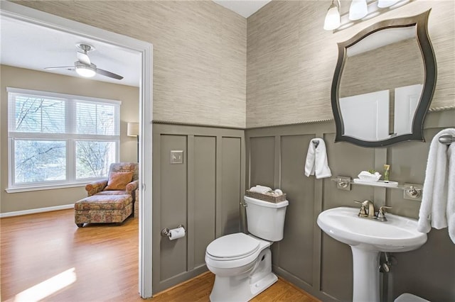 bathroom featuring hardwood / wood-style flooring, toilet, and ceiling fan