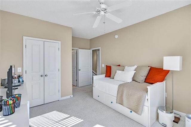 bedroom featuring light colored carpet, a closet, and ceiling fan