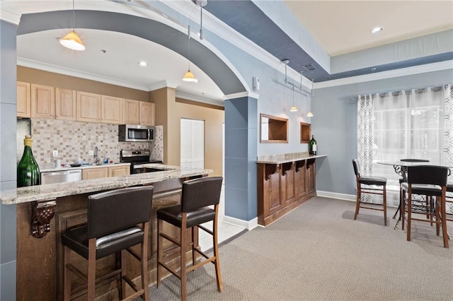 kitchen featuring light carpet, appliances with stainless steel finishes, backsplash, and decorative light fixtures