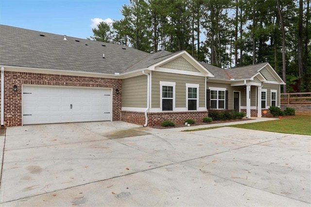 view of front facade featuring concrete driveway, brick siding, roof with shingles, and an attached garage