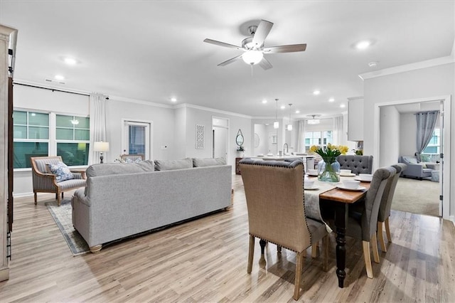 dining space with light wood-style floors, crown molding, and recessed lighting