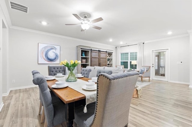 dining space featuring light wood-type flooring, baseboards, visible vents, and ornamental molding